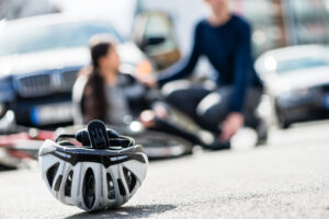 a bicycle helmet close up with a damaged bike in the background