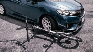 a damaged bicycle underneath a car
