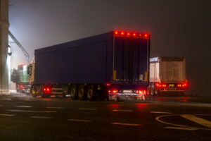 two semi trucks driving at night