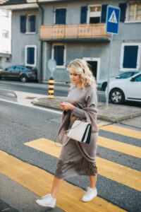 Beautiful woman crossing the road while using smartphone